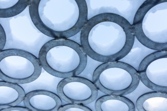 Surface of metal rings, partially covered with snow, detail of the art installation Wunderhorn by