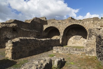 Old stone wall structure with arched recesses at the ancient ruins of Pompeii, Campania region,