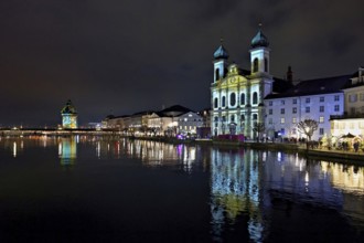 Water tower and Jesuit church on the right with light installation, on the Reuss at dusk, Old Town,