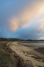 Coastal path along the beach at dusk with soft clouds in the sky, Plage de Raluzet, Plougrescant,