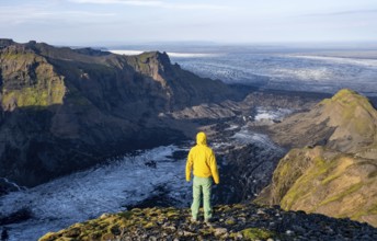 Young man, tourist in front of impressive landscape with glacier in the evening light, glacier