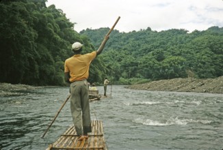 Rafting on the Rio Grande, Port Antonio, Jamaica, Caribbean 1970 Man pushes raft down river through