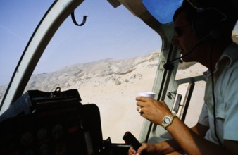 Oil industry Saudi Arabia, helicopter Bell 206 JetRanger 1979 Pilot in cockpit flying over desert