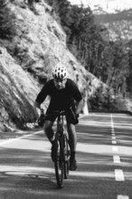 Road bike rider in spring in the Allgäu against the picturesque backdrop of the Alps, Bavaria,