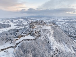 Aerial view of the snow-covered Hegau volcano Hohentwiel with Germany's largest castle ruin on a