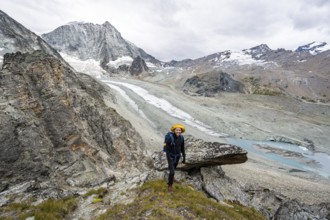 Mountaineer at Col de Riedmatten, view of glacier Glacier de Cheilon and mountain peak Mont Blanc