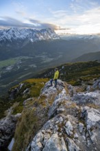 View of Wetterstein mountains with Zugspitze, mountaineer at the summit of Kramerspitz, at sunset,