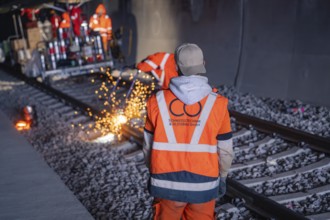 Observing workers watching welding work with spark spraying in the tunnel, rail welding, track