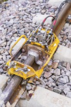 Yellow technical device on the tracks, surrounded by stone ballast, rail welding, track