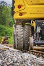 Close-up of a construction machine working on rails in a forest landscape, track construction,