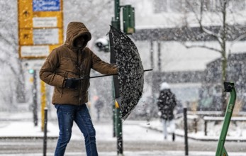 Winter weather, heavy snowfall, city centre traffic, passers-by in the snow, North