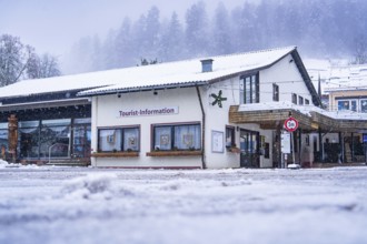 Tourist information centre surrounded by snow-covered hills and forests in winter, Enzklösterle,