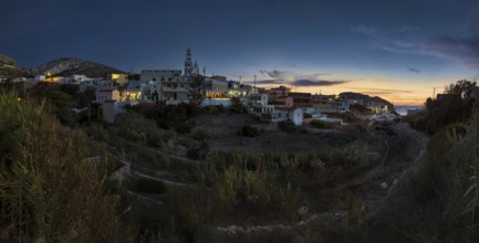 Town view of Arkasa at dusk with soft lights and calm atmosphere, Arkasa, Karpathos, Greece, Europe