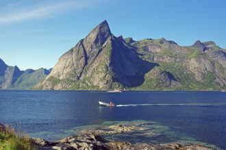 Small boat sailing over the Reinefjorden, high, rugged, mountains, Nordland, Norway, Europe