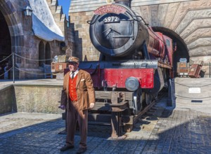 Conductor near train locomotive at Hogsmeade station in The Wizarding World of Harry Potter in