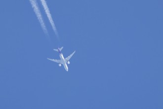 Airbus A300 jet aircraft of Fedex airlines flying in a blue sky with a vapor trail or contrail