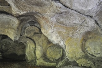 Grooves and circles in the sandstone rock from carving millstones at the Hohllay cave in Berdorf,