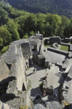 Tourists with audio guide walking among ruins of the medieval Bourscheid Castle, Luxembourg, Europe