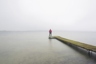 Man on wooden jetty at Großer Plöner See, Great Plön Lake, Lake Plön, Grosser Ploener See in