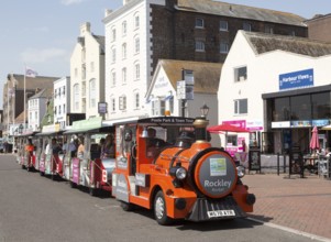 Rockley Rocket land train passing old historic buildings on quayside at Poole harbour, Poole,