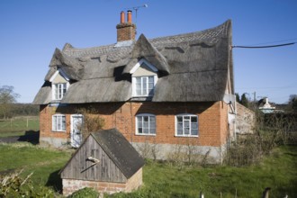 Traditional thatched cottage with well in garden, Sutton, Suffolk, England, United Kingdom, Europe