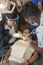 Female volunteer dentist provides dental services through Mission Smiles mobile dental clinic in