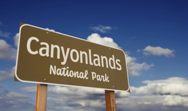 Canyonlands national park (utah) road sign against blue sky and clouds.-