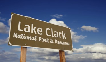 Lake clark national park and preserve (alaska) road sign against blue sky and clouds