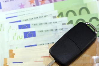 Euro banknotes and car keys as a symbol for car costs