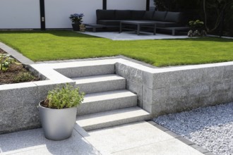 Well-kept ornamental garden with granite wall and block steps