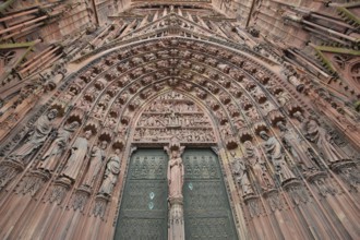 West façade main portal with tympanum and decorations, figures, view upwards, detail, church door,