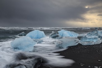 Ice floes on the beach, waves, sea, clouds, sunlight, winter, Diamond Beach, Breidamerkursandur,