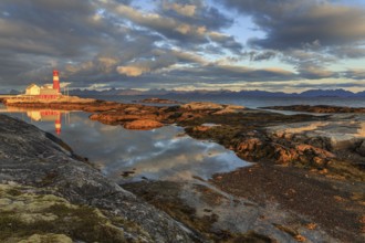 Lighthouse reflected in water, morning light, clouds, mountains, coast, Tranoy, Ofoten, Norway,