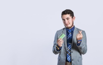 Smiling businessman holding credit card isolated. Business man holding credit card making money