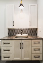 Antique finish wooden cabinet with black nuanced laminated countertop and ceramic backsplash in