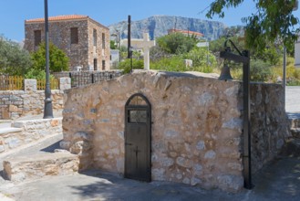 Rustic stone building in a Mediterranean landscape under a blue sky, Church of Agios Nikolaos,