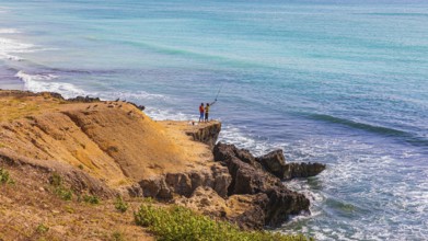 Anglers stand on the cliff at Mughsail Beach on the Arabian Sea, near Salalah, Dhofar Province,