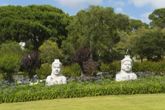 Two Buddha statues in a green, peaceful garden with numerous trees and bushes, Bacalhôa, Bacalhoa