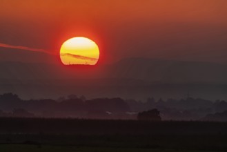 Sunrise, in the background the mountains of the Swabian Alb with wind turbines. Stuttgart,