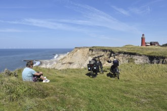 Woman, senior citizen with bicycle at the lighthouse Bovbjerg in Denmark