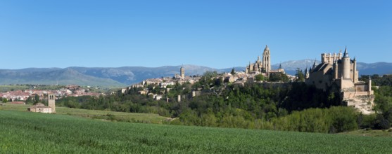 Panoramic view of a historic city with a cathedral and a castle surrounded by green fields and