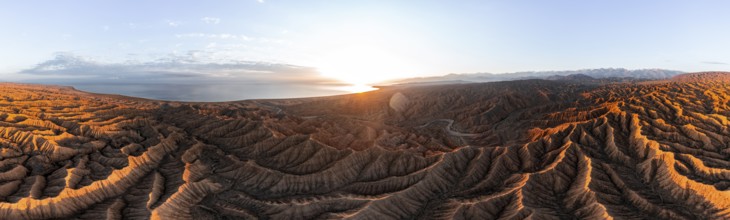 Panorama, landscape of eroded hills, badlands at sunset with Lake Issyk Kul, aerial view, Canyon of