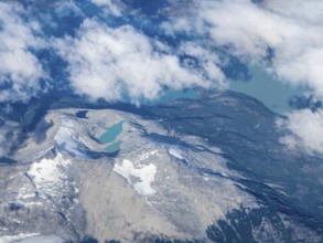 Mountains, white clouds and green lakes, flight over Patagonia, Chile, South America