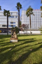 Chusan Palm (Trachycarpus fortunei), garden, lawn, trees, modern architecture, blue cloudless sky,