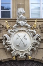 Two crossed halberds on the coat of arms of the Krackhardt merchant family above the entrance