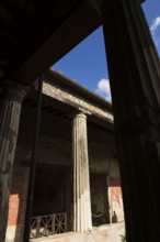 Large old building with silhouetted stone columns at the ancient ruins of Pompeii, Campania region,