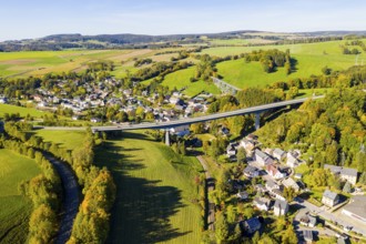 Aerial view of the village with bridge of the federal road 101 in autumn, in the background the