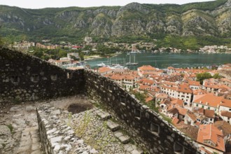 High angle view of walled mountainside walking trail, apartment buildings and houses covered with