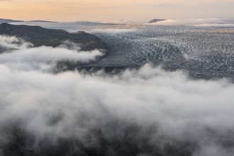 Fog, clouds moving around, glacier ice of the Kötlujökull glacier tongue at sunset, Myrdalsjökull