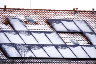 Snow-covered solar modules on a residential building, winter, Germany, Europe